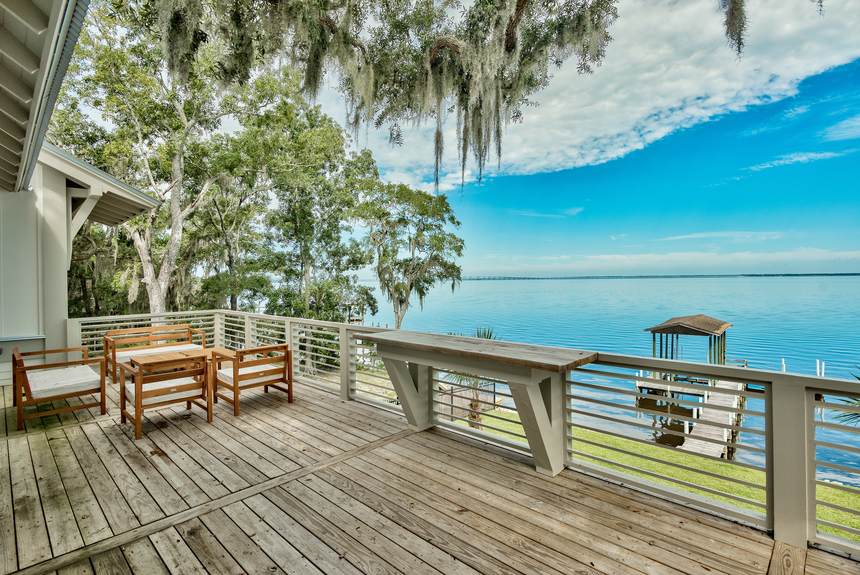 A view of the bay from the private deck of a bay front home beneath moss covered oak trees